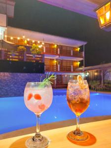 due cocktail seduti su un tavolo accanto alla piscina di Esperanza Hotel - Oxapampa a Oxapampa