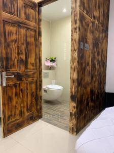 een badkamer met een houten deur en een toilet bij Happy house in Birmingham
