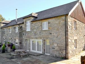 een stenen huis met een picknicktafel ervoor bij The Old Granary in Ballindalloch