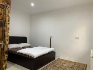 een slaapkamer met een bed met witte lakens erop bij Happy house in Birmingham