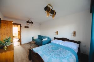 1 dormitorio con 1 cama y 1 sofá azul en Apartament Zielony Ruczaj w Cisnej, en Cisna