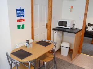 a small room with a table and a microwave at Kimberly Cottage in Alness