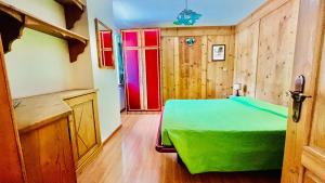 um quarto com uma cama verde e uma janela vermelha em PredazzoHouse em Predazzo