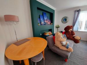 una sala de estar con dos ositos de peluche sentados en un sofá en Teddy Bears' 3-bedroom Maisonette, en Saltcoats