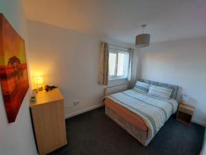 1 dormitorio con cama, escritorio y ventana en Teddy Bears' 3-bedroom Maisonette en Saltcoats