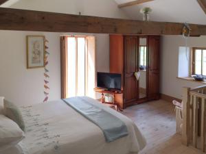 a bedroom with a bed and a television in it at Manor House Dairy Cottage in Ayton