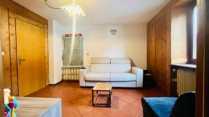 uma sala de estar com um sofá branco e uma cadeira em PredazzoHouse em Predazzo