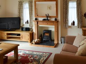 a living room with a fireplace and a tv at The Mount in Boxford