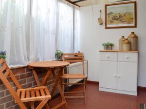 a dining room with a table and chairs and a window at The Mount in Boxford