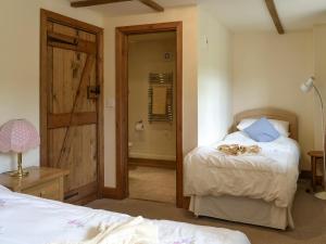 a bedroom with a bed and a door leading to a bathroom at Henwood in East Meon