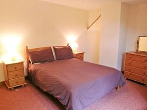 1 dormitorio con 1 cama y 2 mesitas de noche en Denhill Cottage en Chipstable