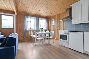 a kitchen and dining room with a table and chairs at Sørreisa Fiske og Feriesenter 
