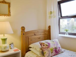 a small bedroom with a bed and a window at Park View Cottage in Old Glossop
