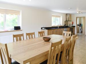 a kitchen and dining room with a wooden table and chairs at March Cottage in Glenrossal