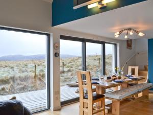 a dining room with a table and a large window at Hygge in Eabost