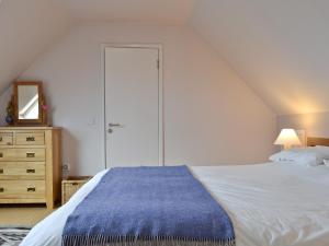 a bedroom with a large white bed and a dresser at Hygge in Eabost