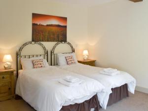 um quarto com 2 camas com lençóis brancos e um quadro em The Gearings - Uk3163 em Lucker