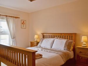 a bedroom with a bed with two night stands and two lamps at Elens Place in Tywyn