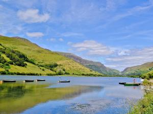 two boats on a lake with mountains in the background at Elens Place in Tywyn