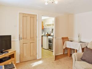 una sala de estar con una puerta que da a una cocina en Dairy Cottage - 28344, en Staintondale