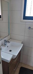 y baño con lavabo blanco y espejo. en Casa Temuco en Cajón