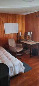 1 dormitorio con cama, escritorio y silla en Casa Temuco en Cajón