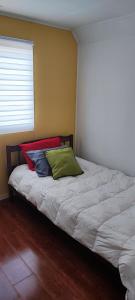 1 cama con 3 almohadas en una habitación en Casa Temuco en Cajón