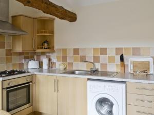 a kitchen with a washing machine and a sink at Basil - E4325 in Ludham