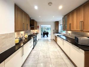 a large kitchen with wooden cabinets and a table at Castlebar in Little Singleton