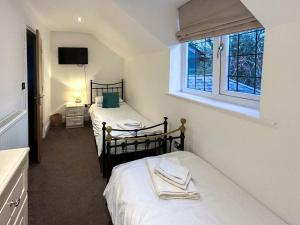 2 camas individuales en una habitación con ventana en Castlebar en Little Singleton