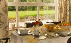 una mesa con platos y gafas y una ventana en The Well Meadow B&B, en Nenagh