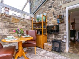 Habitación con mesa y pared de piedra. en Old Brewery Coach House-uk3003, en Haltwhistle