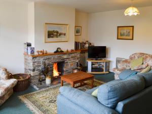 a living room with two couches and a fireplace at Watercolour Cottage in Lerryn