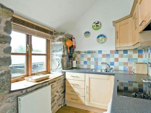 a kitchen with a sink and a window at Llofft Stabal in Llanerfyl