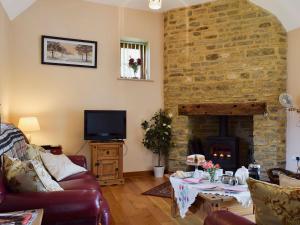 a living room with a couch and a stone fireplace at Alfies Barn in Ambrosden