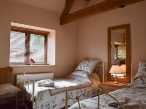 1 Schlafzimmer mit 2 Betten und einem Spiegel in der Unterkunft Alfies Barn in Ambrosden