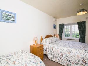 um quarto com 2 camas e uma janela em Katys Cottage em Balnaboth