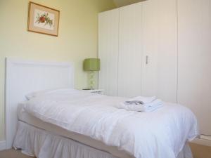 een slaapkamer met een bed met witte lakens bij Barn Owl Cottage in Sudbourne