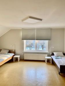 a bedroom with two beds and a large window at Skolas iela , Valmiera in Valmiera