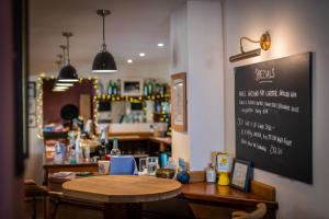 un restaurante con una mesa y una pizarra en la pared en Finnygook Inn en Crafthole