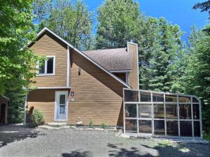 a house with a garage in front of it at Chalet chez Antoine in Saint-Donat-de-Montcalm