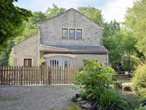 an old stone house with a wooden fence at Sikes Laithe in Kilnsey