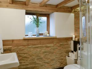 a bathroom with a window and a sink and a toilet at Acorn Cottage in Croft