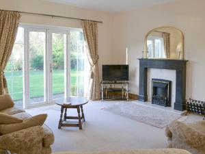 sala de estar con chimenea y TV en Alby Bungalow, en Wetheral