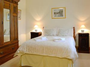 a bedroom with a bed with two towels on it at Alby Bungalow in Wetheral