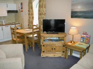 a living room with a flat screen tv on a table at 3 Eldin Hall Properties in Cayton