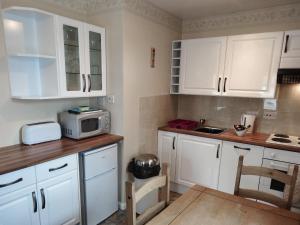 a kitchen with white cabinets and a microwave at 3 Eldin Hall Properties in Cayton
