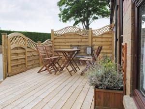 a wooden deck with a table and chairs on it at 3 Eldin Hall Properties in Cayton