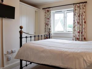 a bedroom with a bed and a window at Misty View in Winchcombe