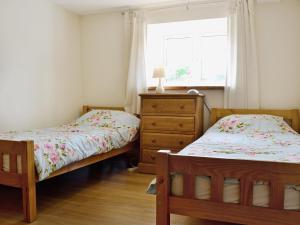 2 camas en un dormitorio con ventana y vestidor en Dol Afon - Hw7588, en Llanuwchllyn